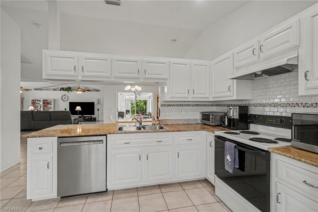 Kitchen featuring white cabinetry, light-colored countertops, stainless steel dishwasher, white subway tile backsplash, and tile flooring