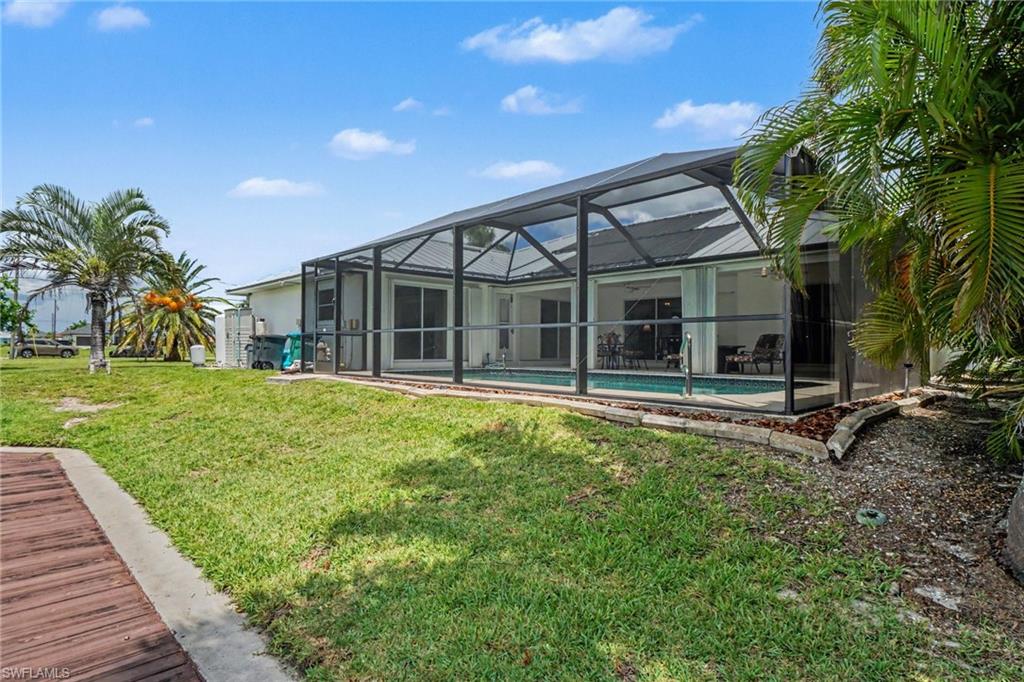 Screened pool enclosure featuring a swimming pool, concrete pool deck, and sliding glass doors