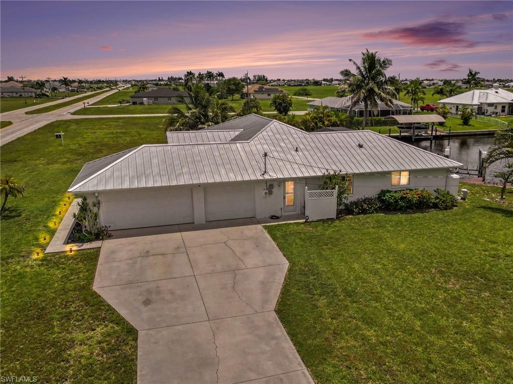 Single-story property with a metal roof, an attached two-car garage, and a concrete driveway