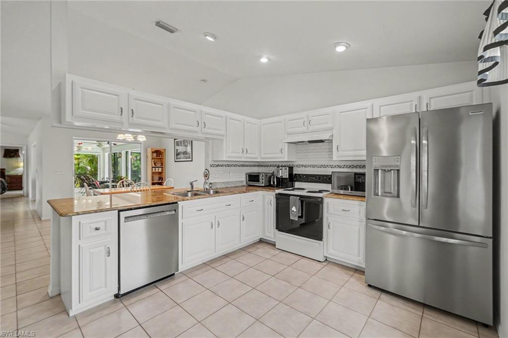 Kitchen featuring white cabinetry, light-toned countertops, stainless steel appliances, and tiled flooring