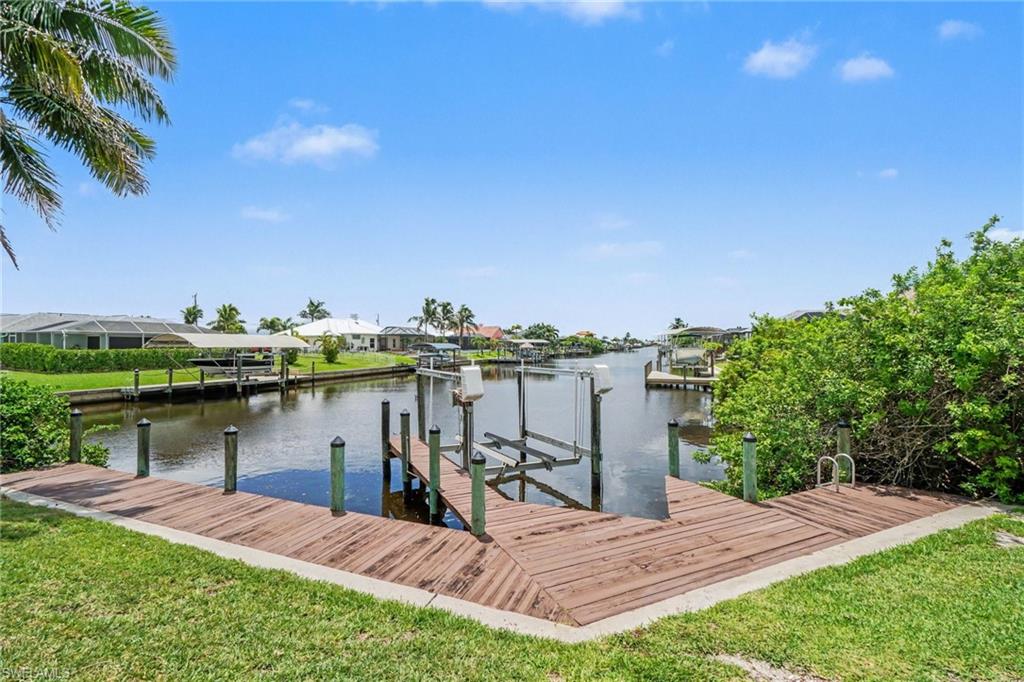 Waterfront property featuring a wood-plank dock with boat lift