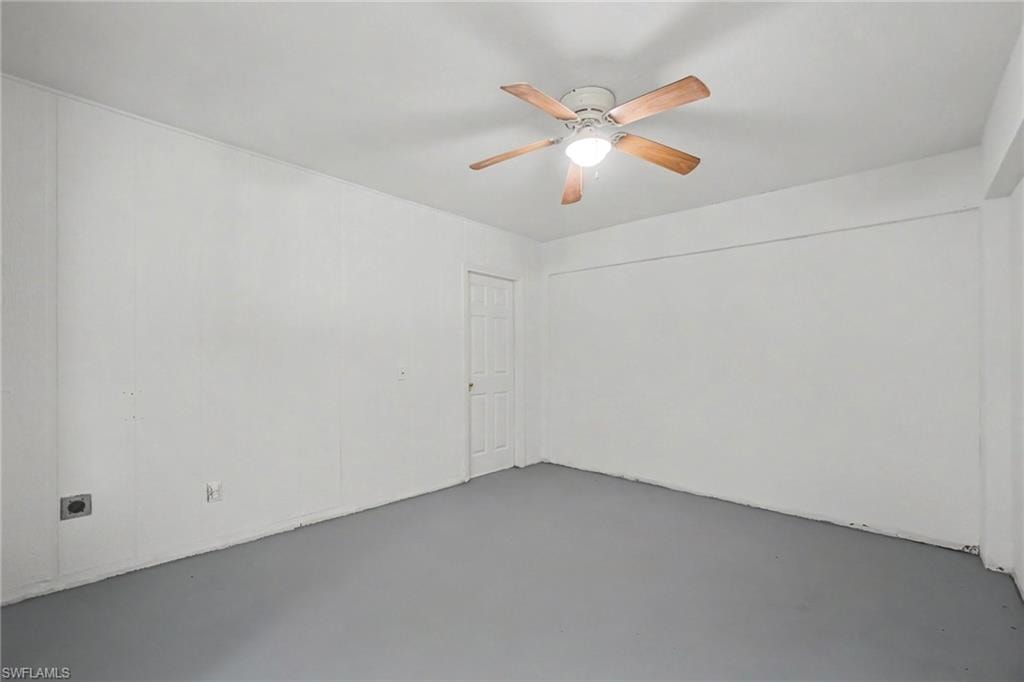 Room with painted walls, ceiling fan with integrated lighting, and a white interior door