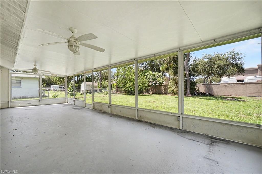 Screened outdoor living area with a concrete floor and dual ceiling fans