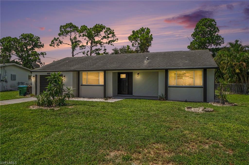 Single-story residence featuring a shingled roof, neutral-toned exterior, and a dark entry door