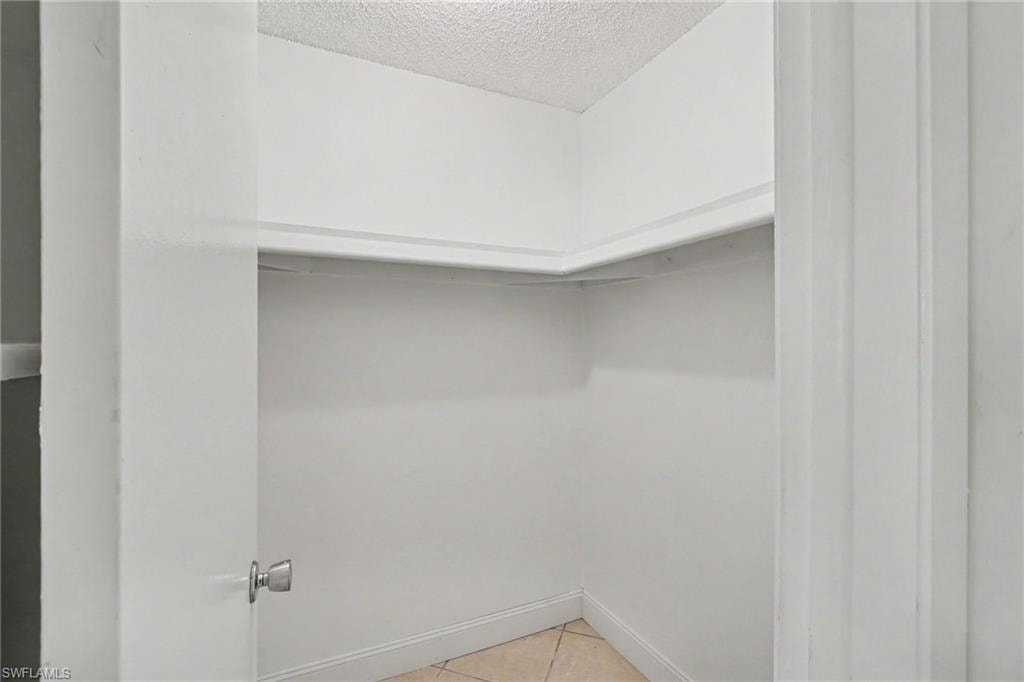 Recessed built-in shelving with tiled flooring and a classic doorknob
