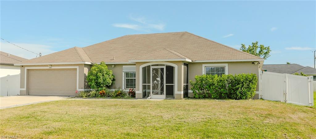 Single-story residence featuring a two-car garage, screened front entry, and a white privacy fence