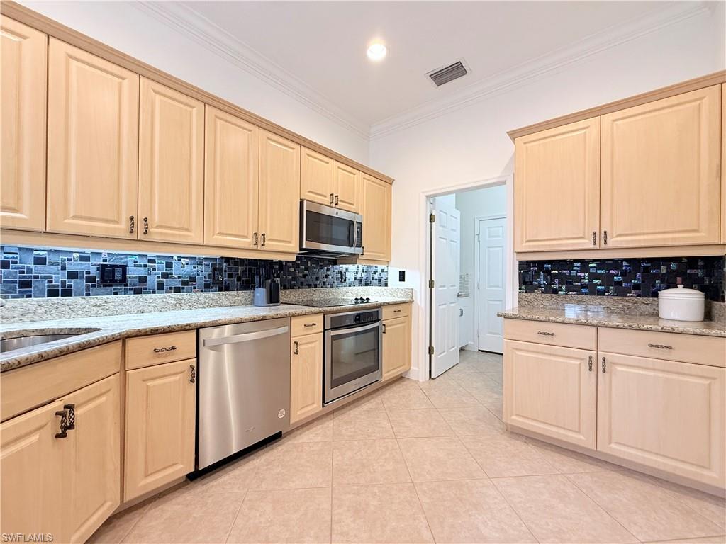 Light wood tone cabinets, granite counter tops, tile backsplash
