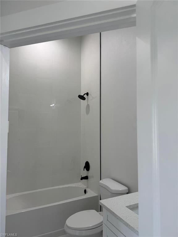 White tiled shower surround with matte black fixtures, white bathtub, and a modern vanity with a light-colored countertop