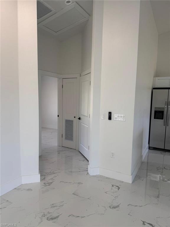 White tile flooring with grey veining, crisp white walls, and white interior doors
