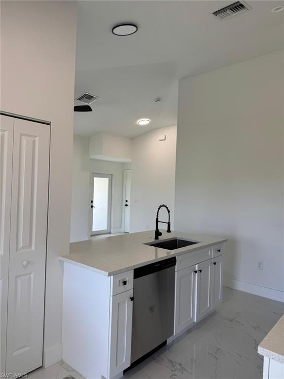Kitchen island with a light-toned countertop, integrated sink, and matte black faucet