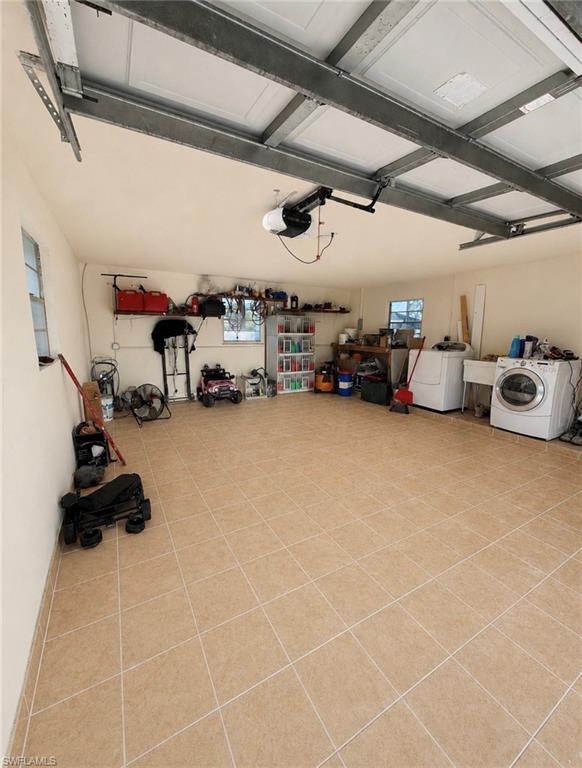 Tiled flooring, built-in shelving, two windows, automatic garage door opener, and overhead garage door track system