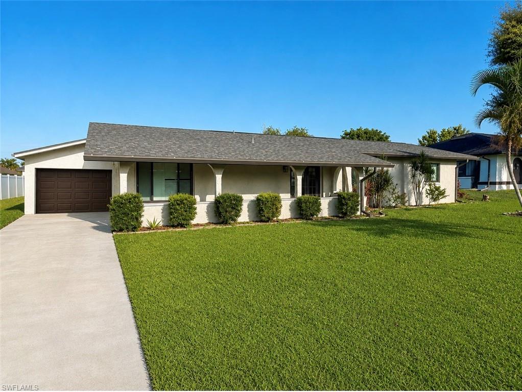 Single-story residence featuring a gray shingle roof and a light-toned exterior