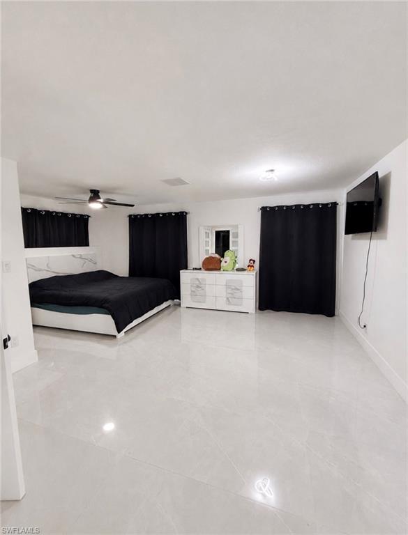 Spacious room featuring light-toned tile flooring, a ceiling fan, recessed lighting, and white walls