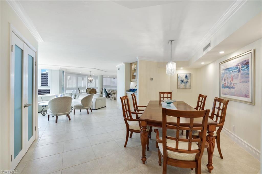 Dining room featuring an inviting chandelier, ornamental molding, and light tile patterned flooring