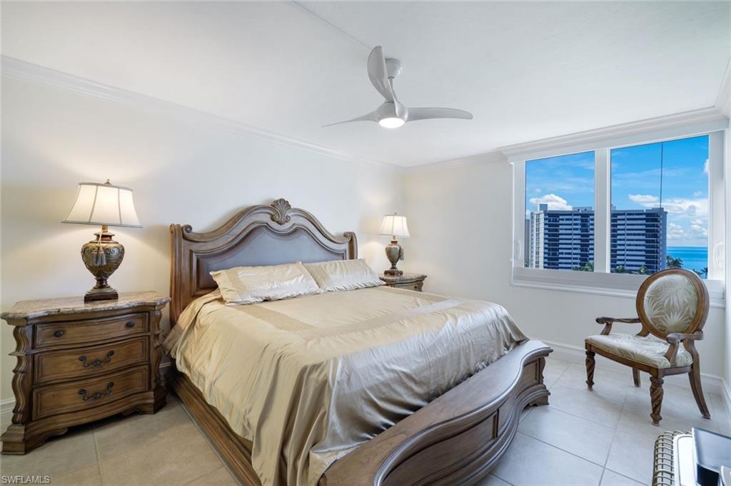 Tiled bedroom with ornamental molding, a water view, and ceiling fan