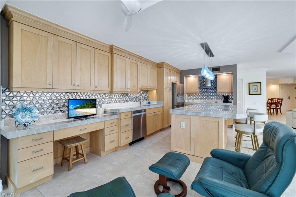 Kitchen featuring appliances with stainless steel finishes, light brown cabinets, and hanging light fixtures