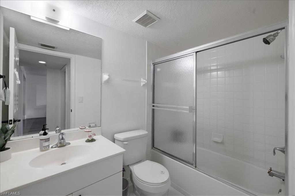 Vanity with integrated sink, chrome faucet, and expansive wall-mounted mirror