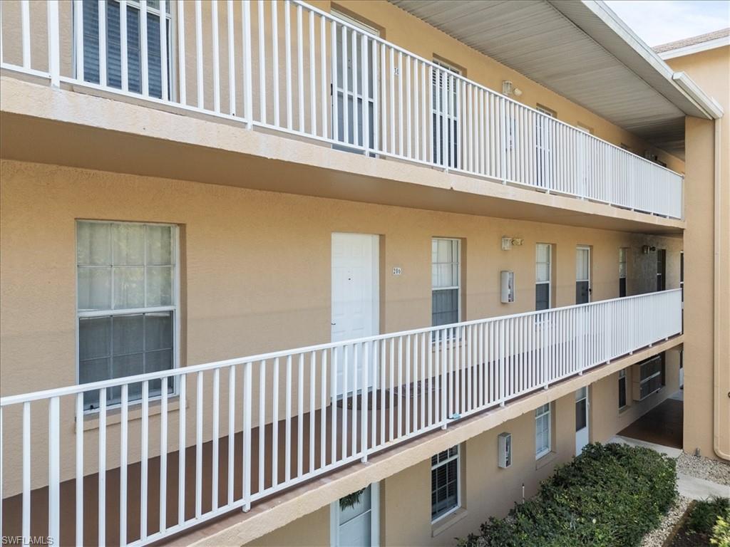 Multi-story building with textured facade and white railing balconies