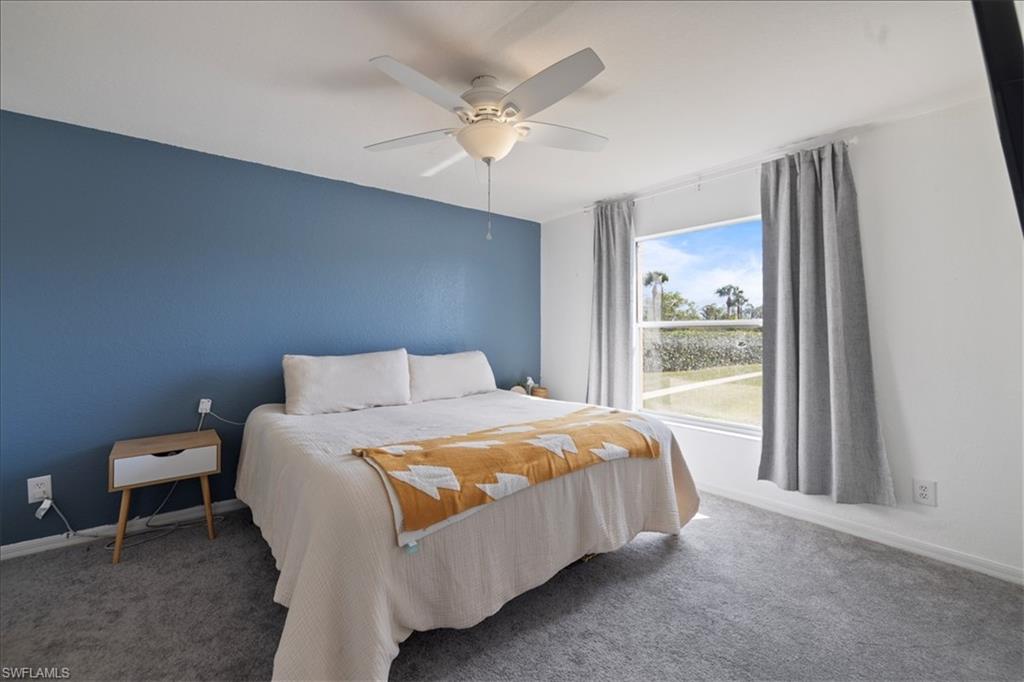 Carpeted bedroom with a ceiling fan