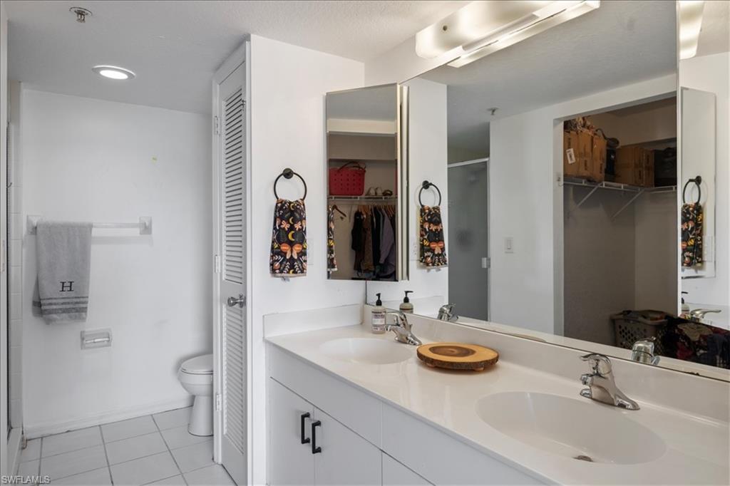 Dual vanity with integrated sinks, chrome fixtures, and a large wall-mounted mirror