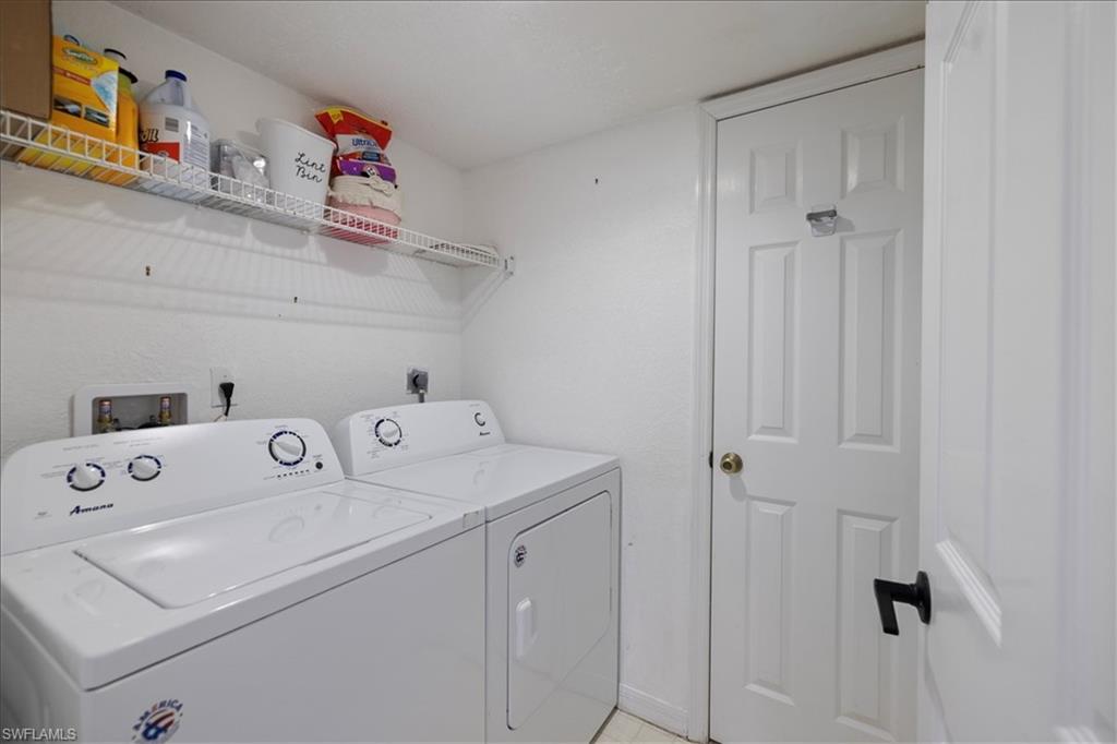 Dedicated utility space featuring a wire storage shelf, a panel door, and white walls