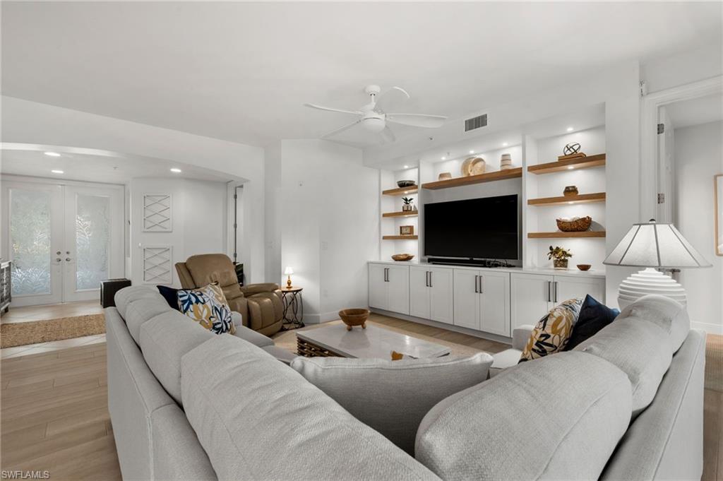 Integrated entertainment center with built-in cabinetry and open wood-finish shelving