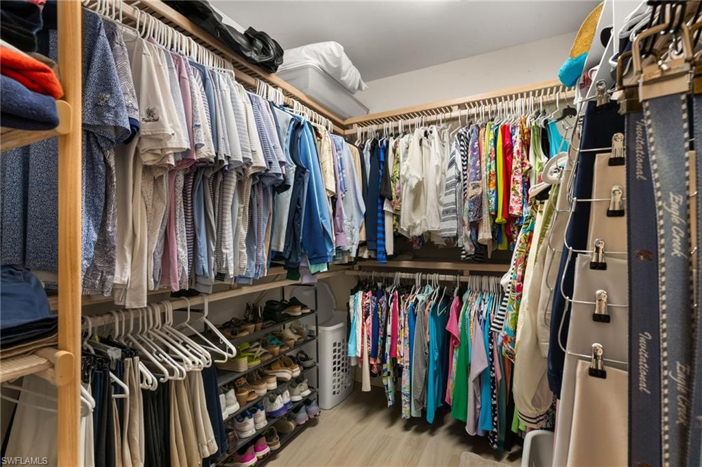 Built-in custom closet system with multiple hanging rods, shelving, and shoe storage