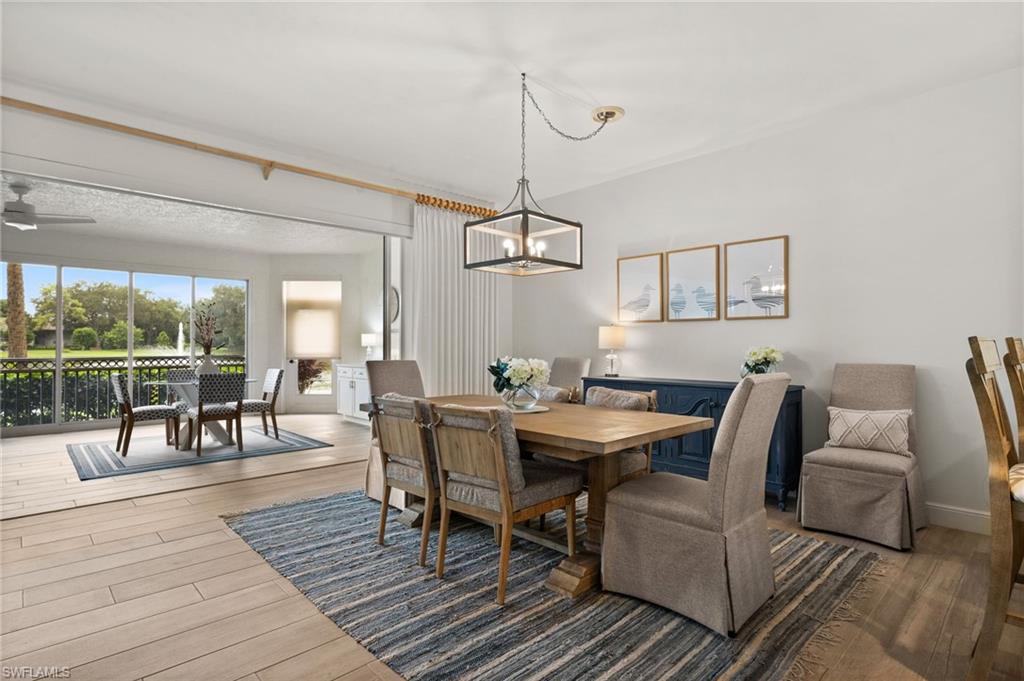 Wood-finish flooring, recessed lighting, and a linear chandelier illuminate this interior space