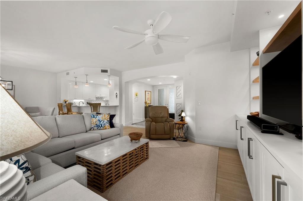 Living space featuring recessed lighting, a ceiling fan, a built-in media console with shelving, and wood-finish flooring
