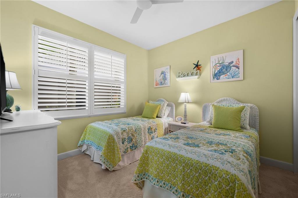 Recessed lighting, ceiling fan, and window with white plantation shutters