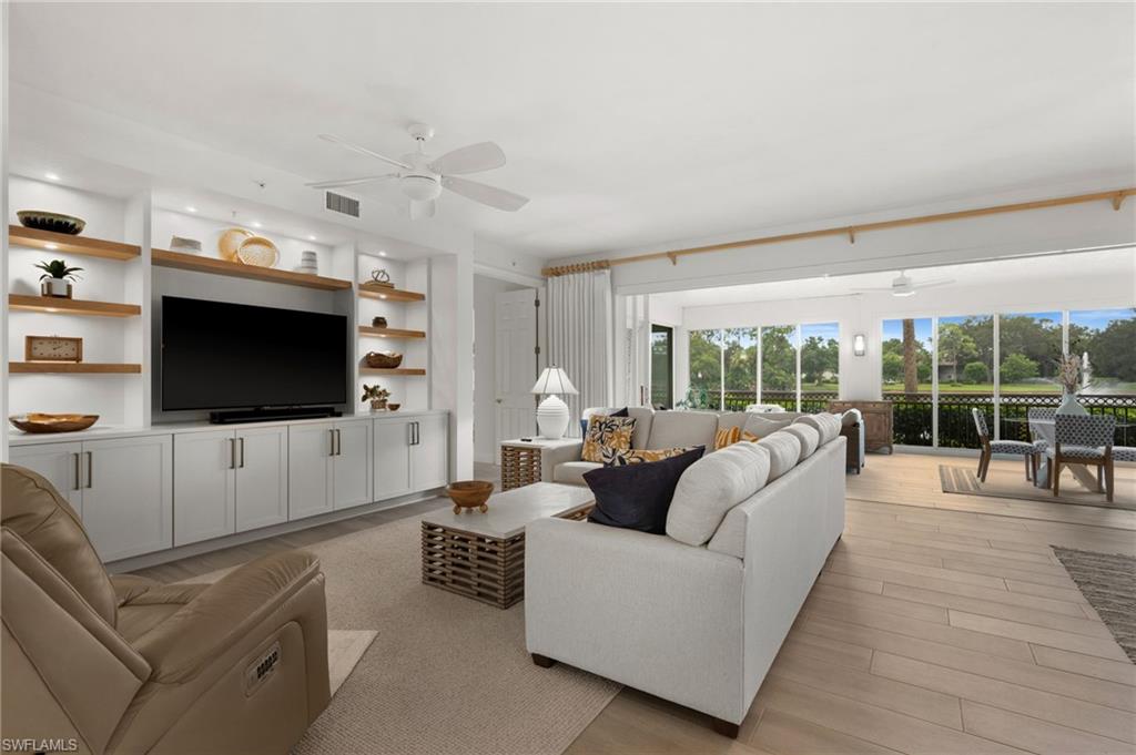 Built-in media center with wood-finish shelving, recessed lighting, and white cabinetry