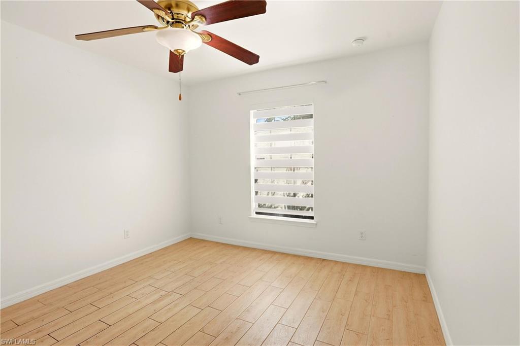 Light wood-finish flooring, recessed ceiling light, and window with horizontal blinds
