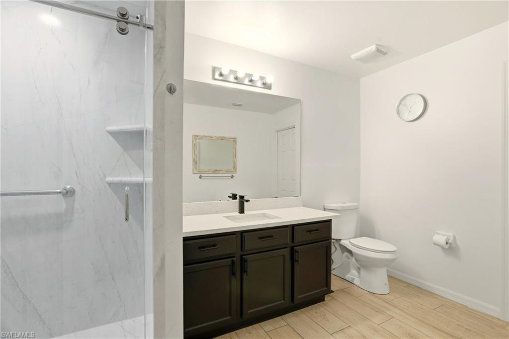 Walk-in shower with clear glass enclosure and integrated shelving