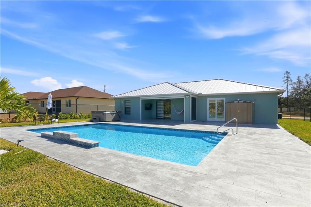 Exterior featuring a swimming pool, integrated hot tub, and a spacious patio