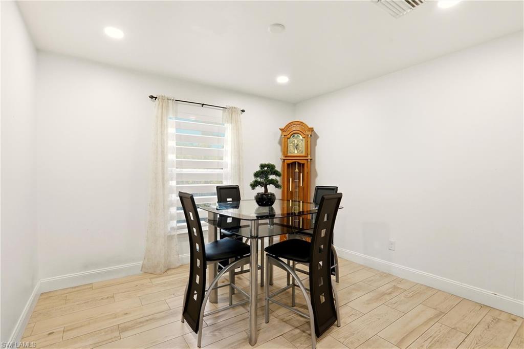 Recessed lighting, wood-finish flooring, and a single window with horizontal blinds