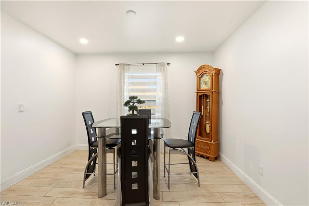 Recessed ceiling lighting, light wood-finish flooring, and white painted walls