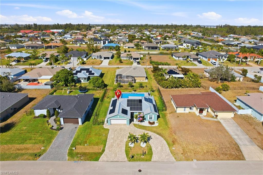 Single-story residence with an attached garage, paver driveway, and a screened swimming pool