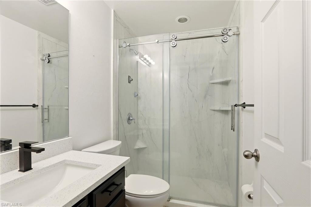 Walk-in shower with sliding glass door and integrated shelving