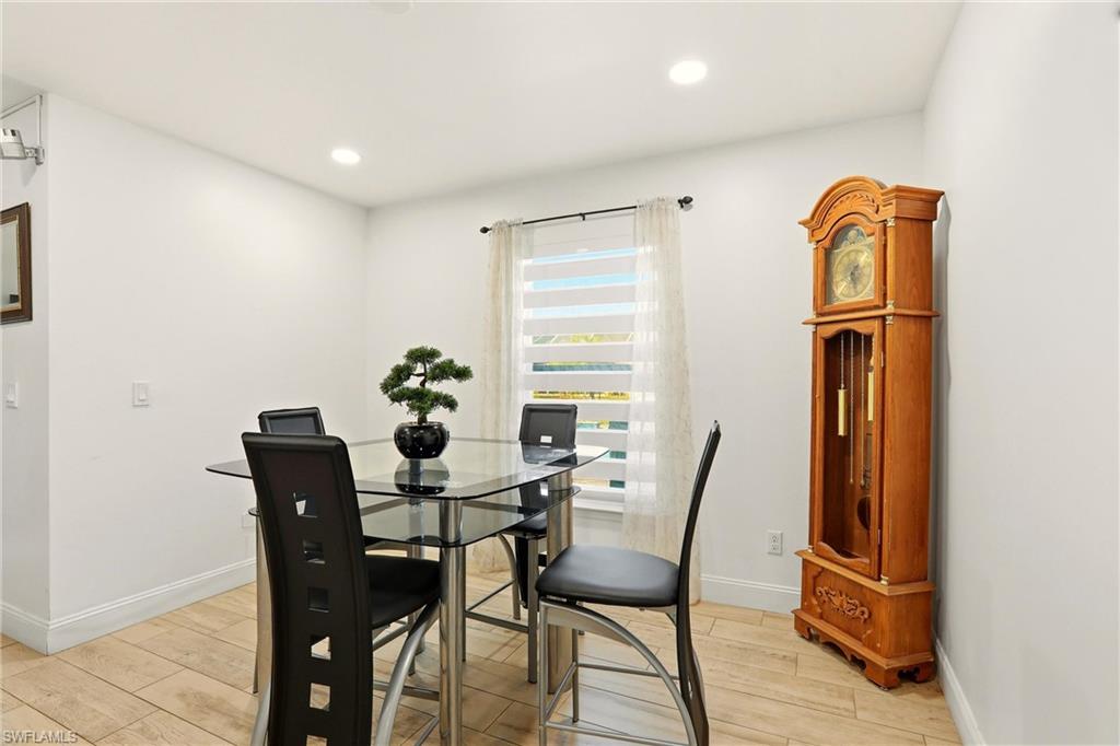 Recessed lighting, light-toned wall paint, wood-finish flooring, white window blinds, and white trim
