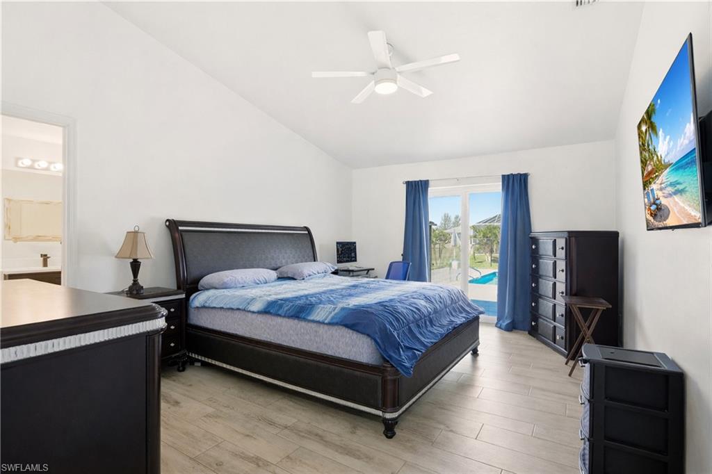 Vaulted ceiling, ceiling fan, tile flooring, glass sliding doors, and direct outdoor access