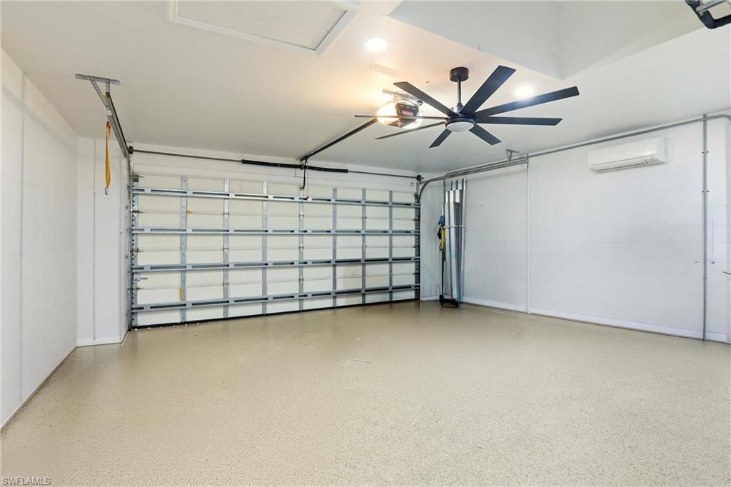Finished garage space featuring a ceiling fan, recessed lighting, and a ductless mini-split system