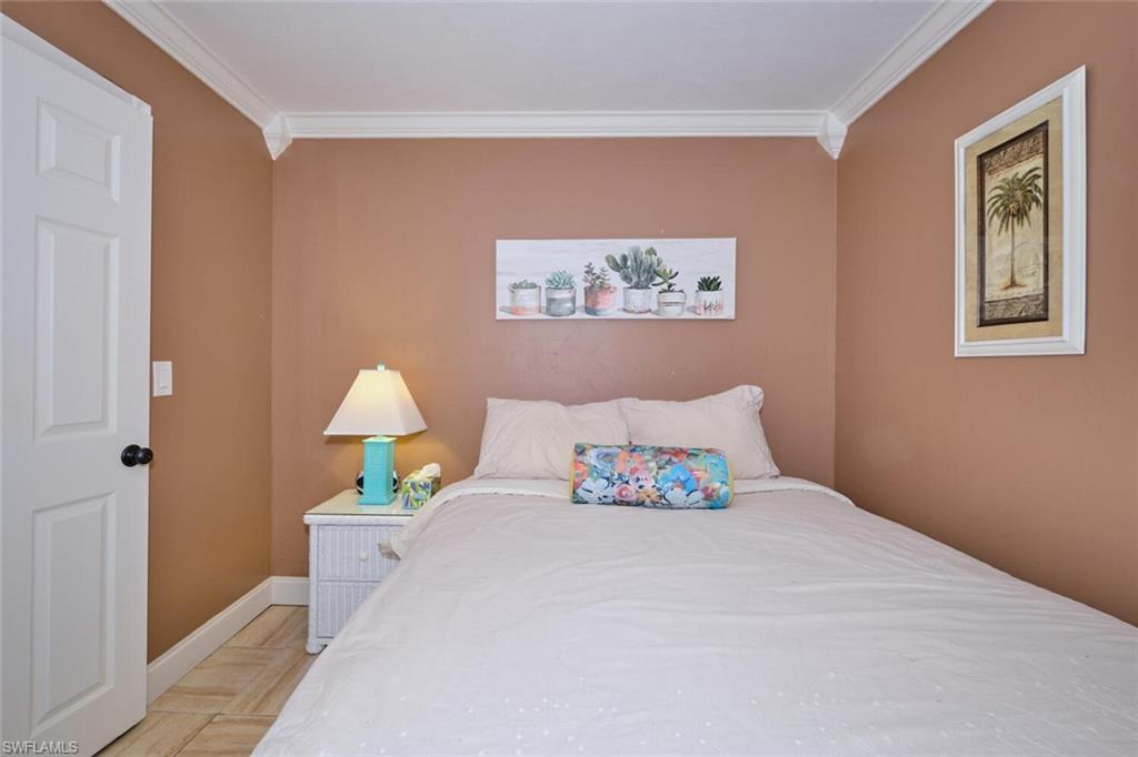 Wall-to-wall ceramic tile flooring, crown molding, and a paneled door with black hardware showing past furniture, unit will have similar type for rental