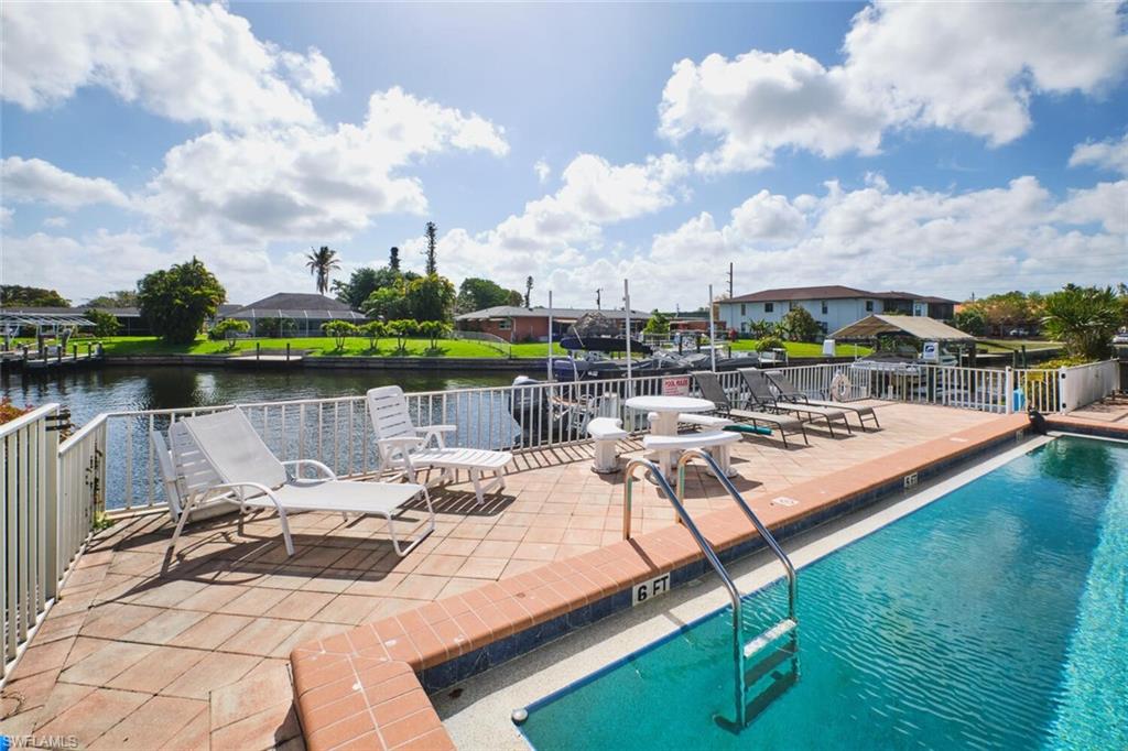Waterfront pool deck featuring a swimming pool with ladder