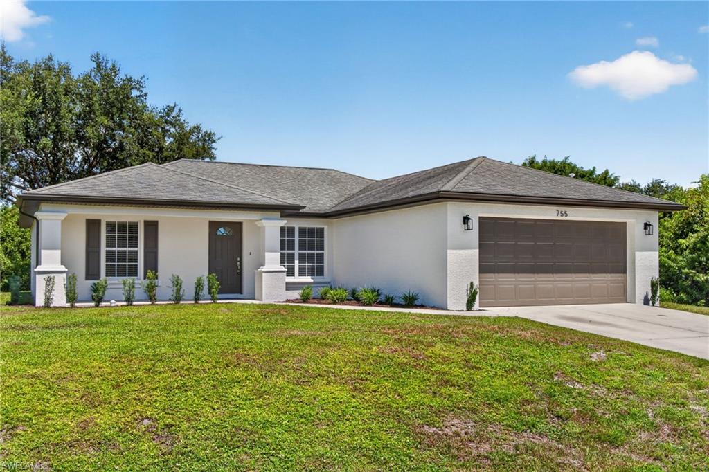 Single-story residence featuring a two-car garage, front porch with columns, and a well-maintained lawn