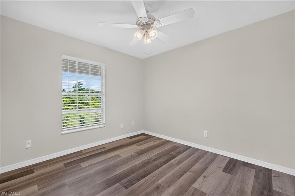 Wood-finish flooring, white window blinds, and a white ceiling fan with integrated lighting