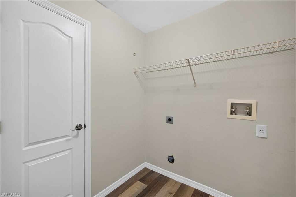 Laundry area featuring a paneled door, wood-finish flooring, and wire shelving
