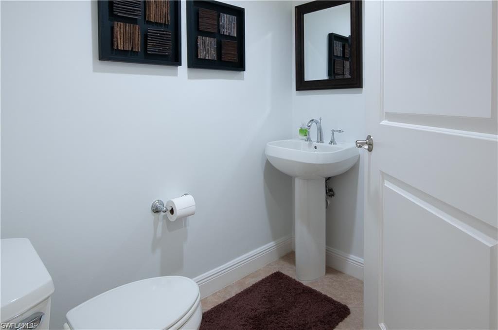 Half bathroom featuring toilet and light tile patterned floors