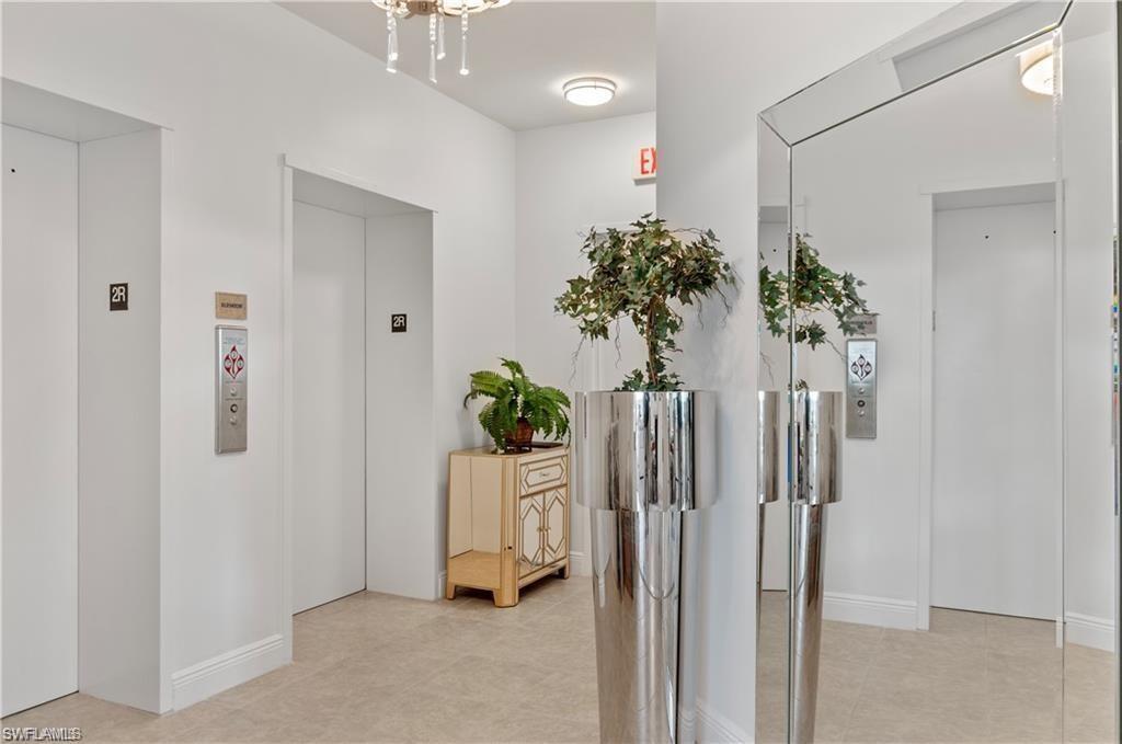 Hall featuring elevator and a chandelier