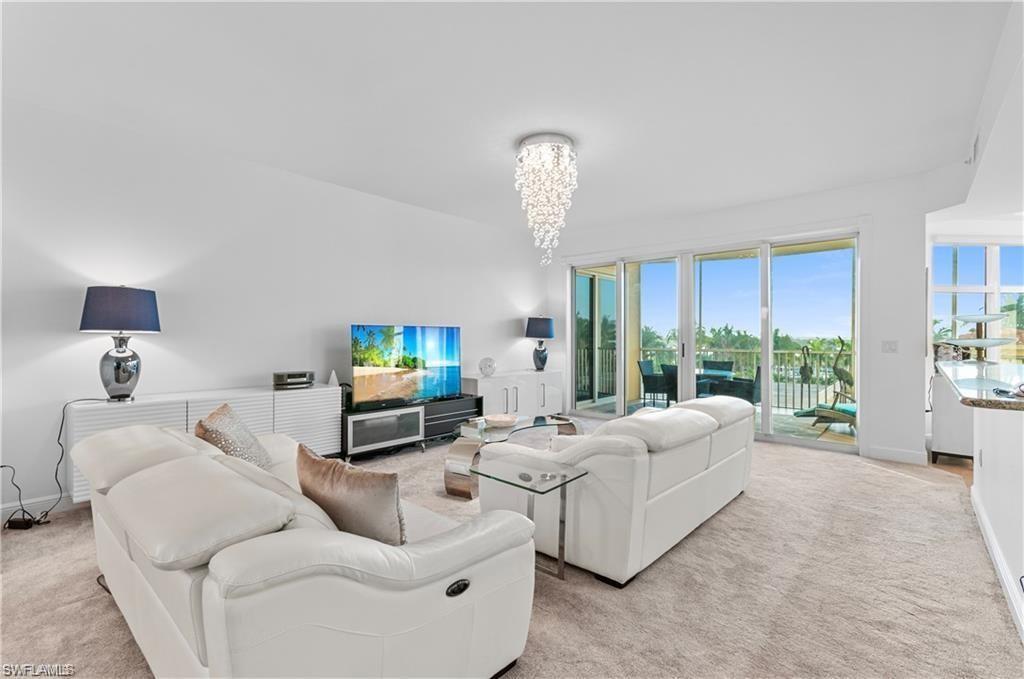 Living room featuring light carpet and a chandelier