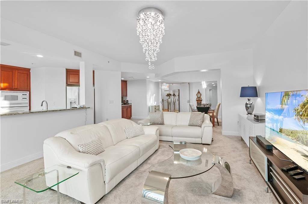 Living room with light colored carpet, a chandelier, and recessed lighting